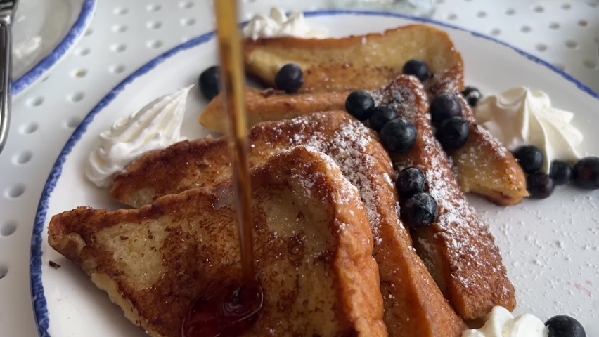 Maple syrup is poured on French toast in slow motion. Royalty-Free Stock Footage #1088860985