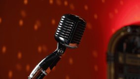 concert stylish microphone on the background of a colored wall with highlights from a disco ball. High quality 4k footage