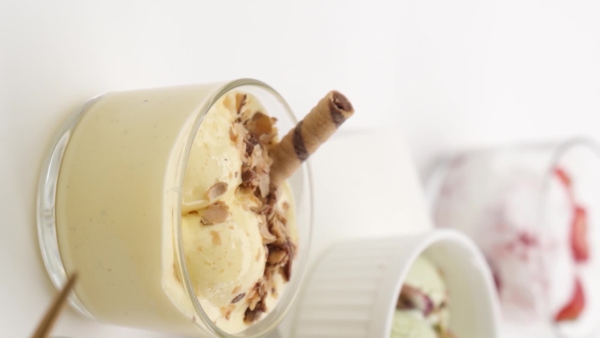 Set of different flavors of ice cream in glasses on a white background
