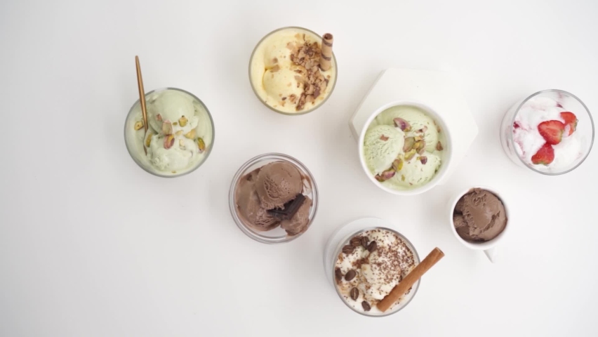 Set of different flavors of ice cream in glasses on a white background
