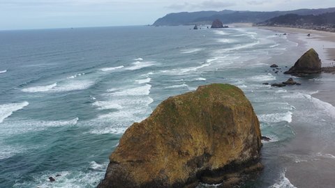 The Pacific Ocean gently washes against a massive sea stack along the Oregon's shoreline, not far west of Portland. The scenic U.S. Route 101 runs right along this beautiful part of the west coast.
