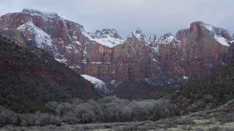 Timelapse video of The Alter of Sacrifice, The Sundial and The West Temple behind the Human History museum in Zion National park Utah on a winter morning with clouds and patches of sunlight.