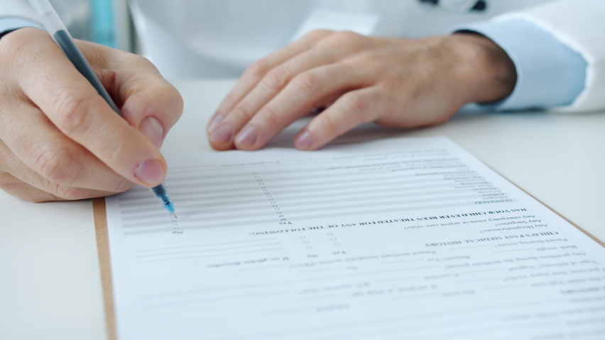 Close-up of male doctor filling in medical chart writing and ticking answers collecting symptoms in hospital. Medicine and healthcare concept. Royalty-Free Stock Footage #1088873405