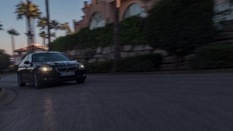 La Alcaidesa, Spain-09.10.2021: BMW 5 series luxury sedan car driving on street with sun-flare, close up view. 