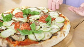 Female hands take a slice of vegetarian pizza with vegetables and tomato sauce. Slow motion food video. Italian pizza restaurant.