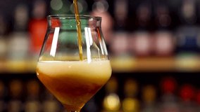 Beer is pouring into glass on bottle background. Slow motion. Macro shot, suitable for ale, lager, IPA, and other types of beer - Powered by Shutterstock - Get 15% off with code: PIKWIZARD15