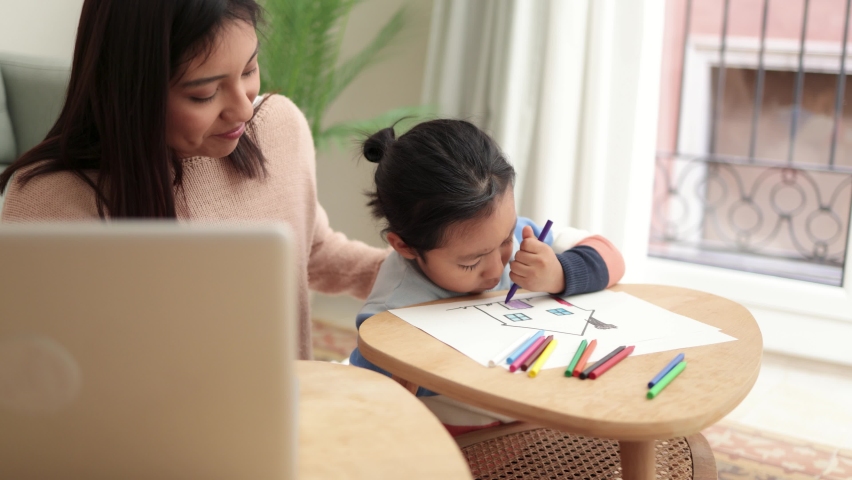 Asian mother taking care of her child painting while using laptop computer at home - Family lifestyle Royalty-Free Stock Footage #1088879209