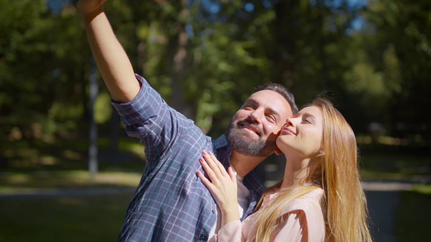 Happy middle aged couple in love making selfie on smartphone, posing together at green park during summer date, slow motion Royalty-Free Stock Footage #1088883777