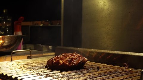 closeup of a picanha cooking on the grill at night in 4k