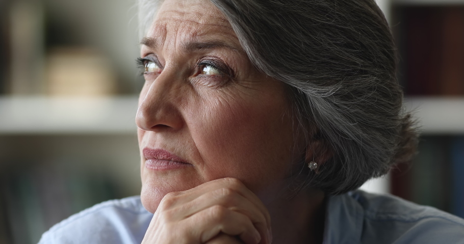 Close up face brooding older businesswoman staring aside feel concerned or exhausted take break at workplace, looking deep in thoughts. Pensive mature female thinking, ponders alone sit indoor concept Royalty-Free Stock Footage #1088885211