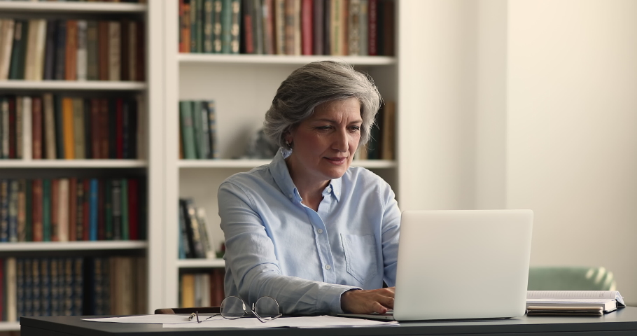 Older woman sit at desk check e-mail on laptop read message feel overjoyed looks very happy due business growth and sales increase, advance and success. Got great news celebrate moment of win concept Royalty-Free Stock Footage #1088885291