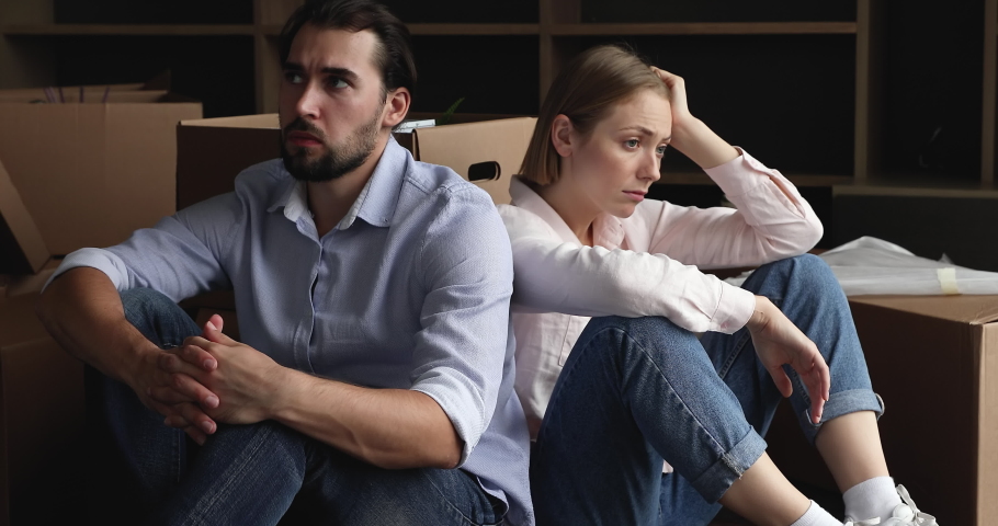 Exhausted spouses sit rest on floor in living room near heap of cardboard boxes look unmotivated to unpack their stuff, feel tired. Financial problem, debt and eviction, hard move day, divorce concept Royalty-Free Stock Footage #1088885417