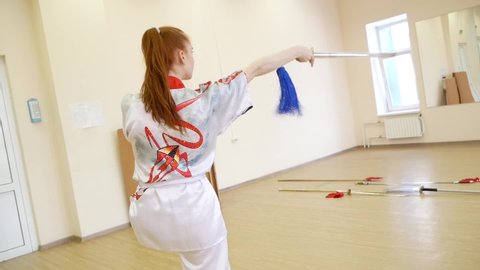 Chelyabinsk, Chelyabinsk region, Russia - 02.06.2022: Girl demonstrates martial arts.

Sharp and smooth movements of the arms and body at the right angle.
