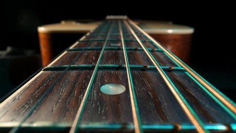 Acoustic guitar fretboard macro closeup slider shot