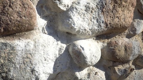 An efflorescence effect sample - salt deposits on stone masonry. A close-up view of a boulder wall in a historical building. The castle ruins stone construction fragments in macro with salt sediments.