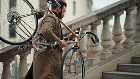 Young stylish man carrying his bicycle upstairs, retro bike in sunny day. - Powered by Shutterstock - Get 15% off with code: PIKWIZARD15