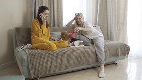 Beagle Puppy Is Loved By Two Women On Couch In Living Room Alt