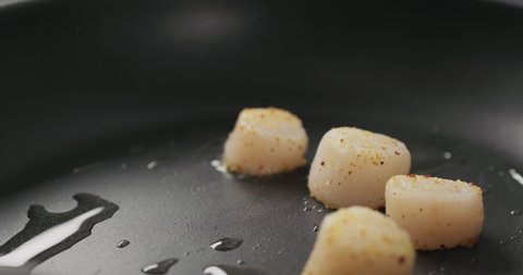 Slow motion put scallops on a non stick pan