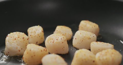 Slow motion frying scallops on a ceramic pan