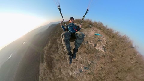 Man flying the paragliding above the mountains at sunset, adventure concept