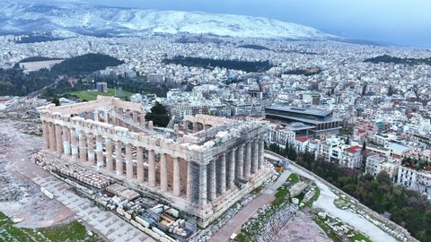 snow in Athens, flying around the Parthenon, aerial view of famous Greek tourist destination in winter, tourism in Greece concept. High quality 4k footage