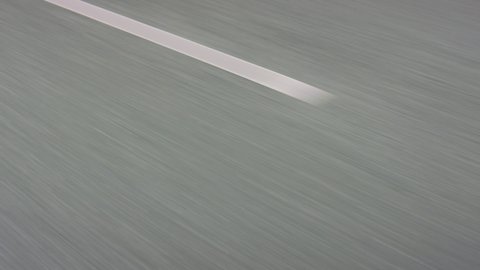 View of a asphalt road with white markings, car driving fast, stabilized footage