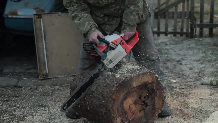 Unrecognizable man harvesting firewood. Woodcutter