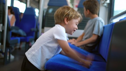 Mischievous children traveling by train kids not behaving playing with seats