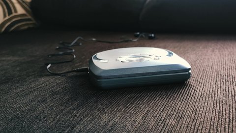 Portable cd player known as discman leaning on sofa at home