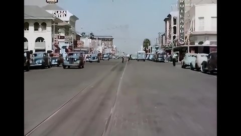 CIRCA 1940s - A traffic cop directs vehicles and pedestrians in Florida.