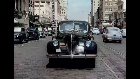 CIRCA 1940s - A mail car drives towards the camera down a main thoroughfare in Florida.
