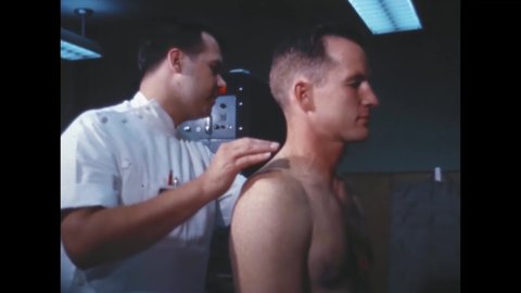 CIRCA 1960s - A doctor checks astronaut Ed White's neck and shoulder region.