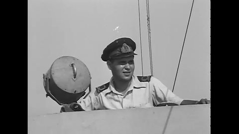 CIRCA 1945 - A British Naval fleet sails towards Burma, with some views shot through a porthole and wheelhouse port window.