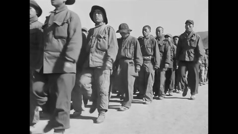 CIRCA 1951 - North Korean POWs sing the Song of the Brave while they march inside a prison camp.
