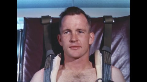 CIRCA 1960s - Astronaut Ed White is harnessed to a table in the Flight Medicine Laboratory, then poses in his air force uniform outside.