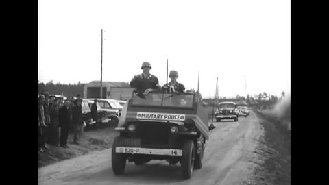CIRCA 1949 - General Clay arrives at review grounds in Grafenwohr, Germany, and rides in the turret of an M-24 tank.