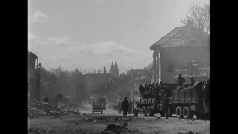 CIRCA 1945 - American soldiers of the Signal Corps set up lines and vehicles of the 11th Armored Division advance through Bayreuth, Germany.