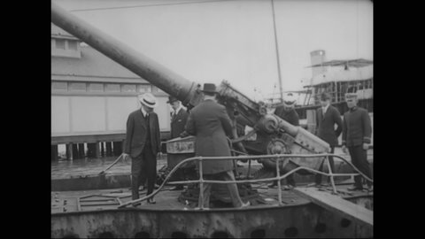 CIRCA 1918 - US Navy officers tour men around the top of a submarine, showing them how to raise the big guns.
