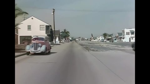 CIRCA 1940s - A camera fixed on a car is driven down a main road in Newport Beach, California.