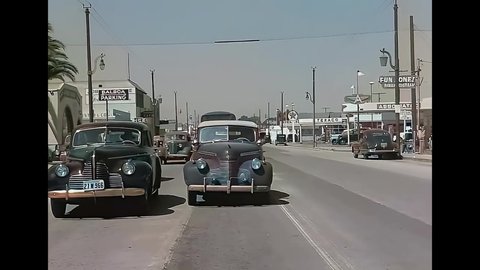 CIRCA 1940s - Cars drive through a residential area in Newport Beach, California.