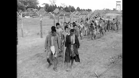 CIRCA 1945 - Wounded Japanese POWs are herded towards a medical station, some of whom are missing limbs.