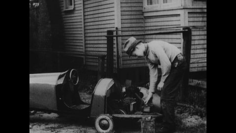 CIRCA 1933 - A boy builds his own small car to drive along the sidewalk on his paper route.