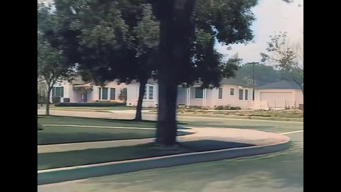 CIRCA 1940s - A car drives through a residential neighborhood in Burbank, California.