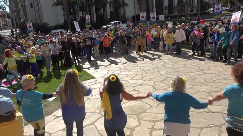 SANTA BARBARA, CALIFORNIA - CIRCA 2022 - Ukranians and anti war protesters dance in a circle and pray together during a Ukraine peace rally.