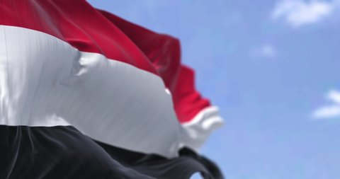 Detail of the national flag of Yemen waving in the wind on a clear day. Yemen is a country in Western Asia. Selective focus. Seamless looping in slow motion