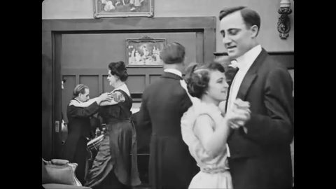 CIRCA 1917 - In this silent comedy, a man (Charlie Chaplin) tries to spy at a party but his view is blocked by a small man dancing with a large woman.
