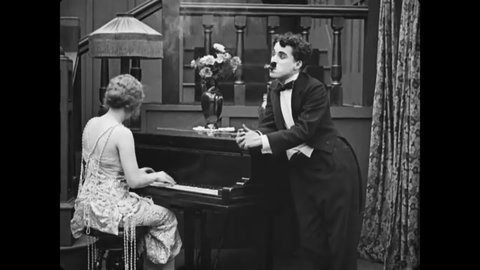 CIRCA 1917 - In this silent comedy, a man (Charlie Chaplin) sprays his rival with seltzer to get him to stop kicking him.