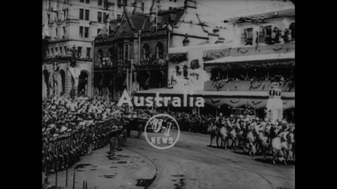 CIRCA 1954 - Queen Elizabeth II's motorcade drives down crowd-lined streets in Australia, and the Queen then sees Aboriginal men dance.