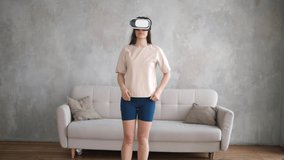 Young woman trains at home, runs in a virtual park and wears virtual reality glasses. Woman wearing VR headset glasses.