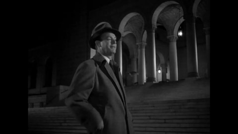 CIRCA 1949 - In this film noir, a reporter harasses a woman walking alone on the sidewalk at night.